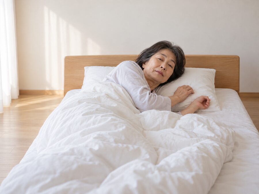 ベッドで横向きに寝返りを打っている女性