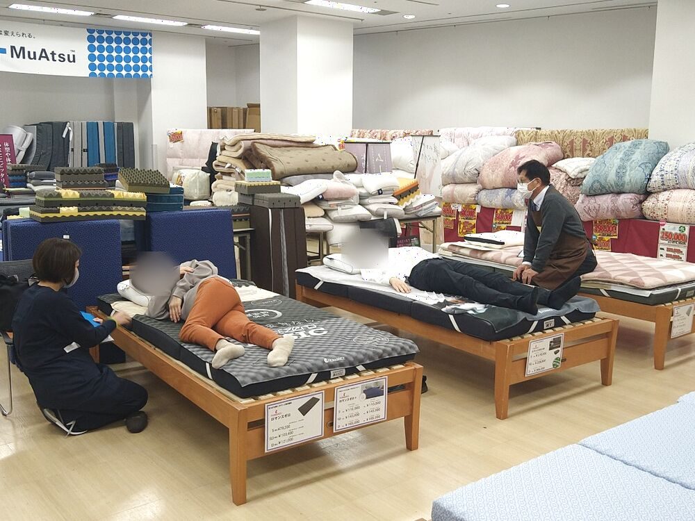 何人ものお客さまがマットレスをお試し中の会場